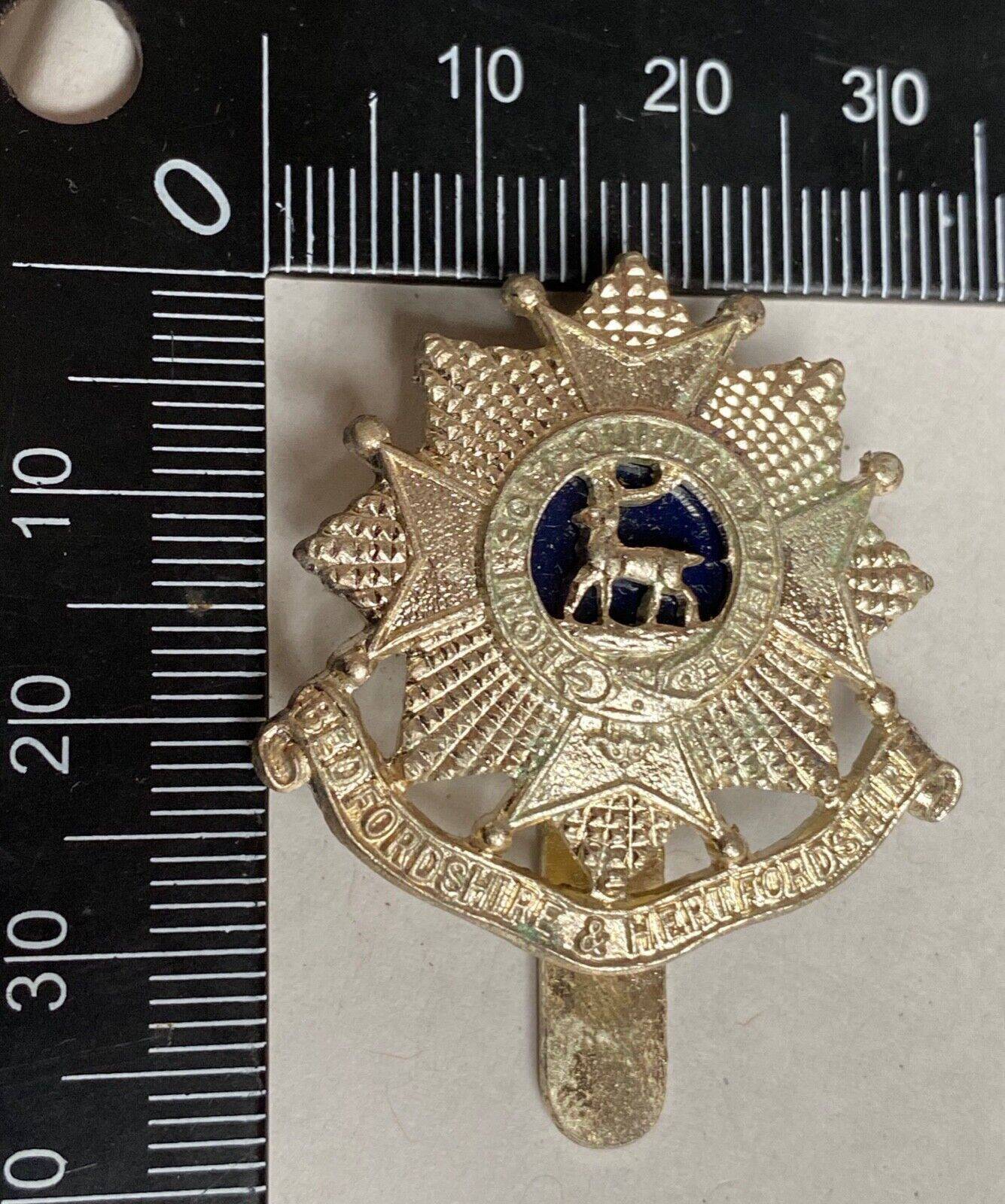 A white metal British Army Bedfordshire & Hertfordshire Regiment cap badge. - The Militaria Shop