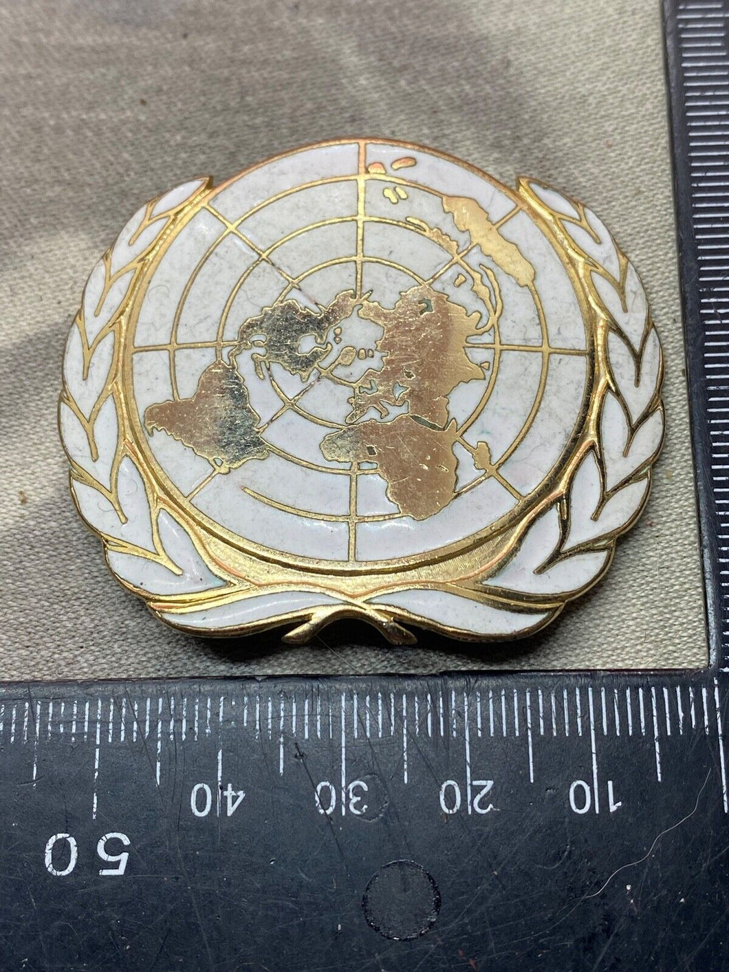 Original United Nations Gilt and White Enamel Beret / Cap Badge