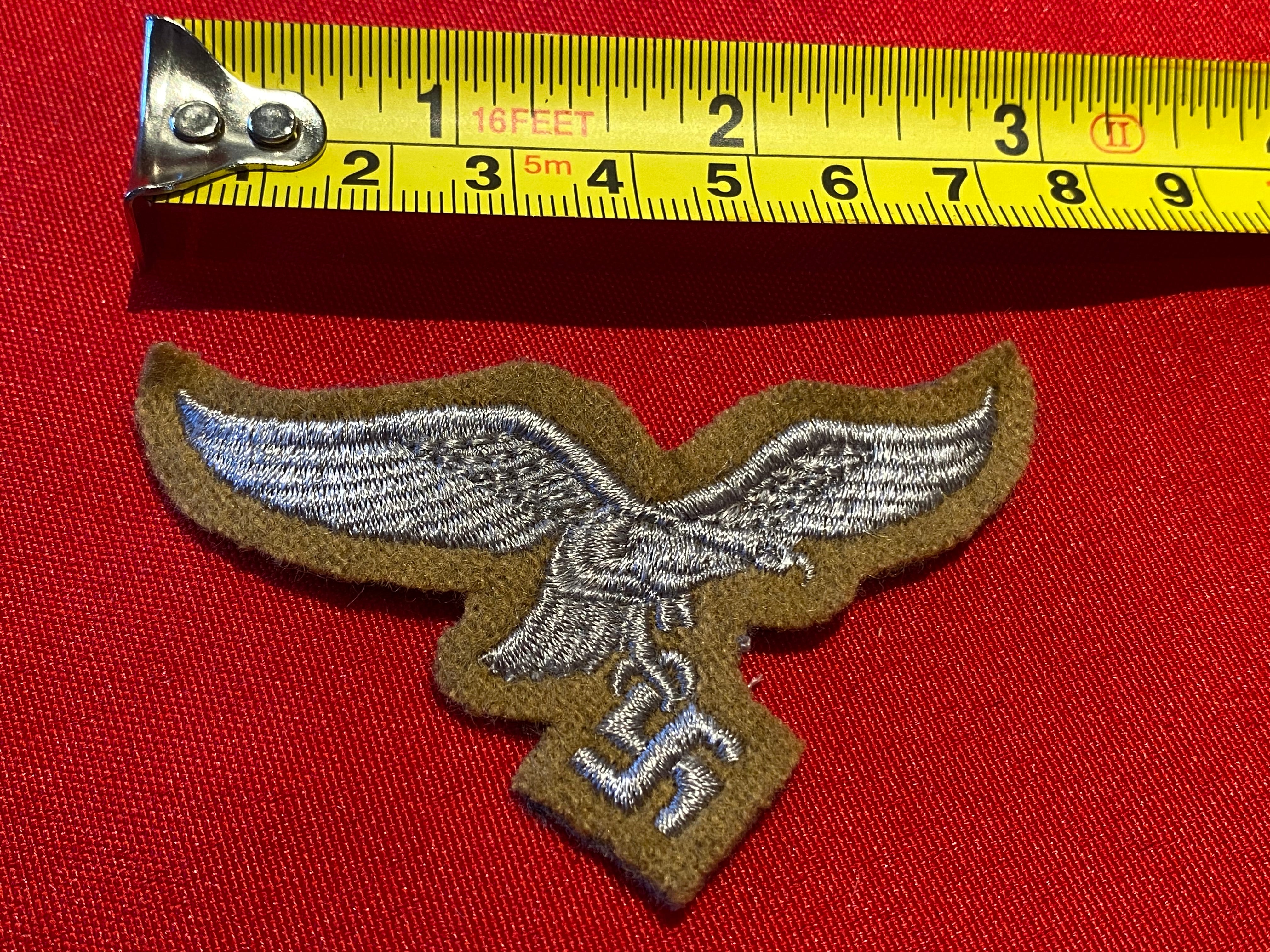 Reproduction Luftwaffe Tropical Breast Eagle badge on a tan background. - The Militaria Shop