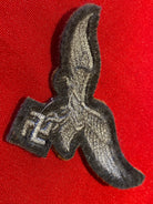 Reproduction Luftwaffe Tropical Breast Eagle badge on a tan background. - The Militaria Shop